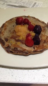 Chocolate protein pancake with stewed plums and frozen berries. 